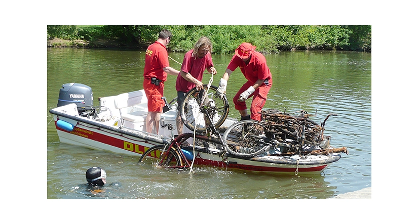 Das Foto zeigt Freiwillige der DLRG, die ein Fahrrad aus der Lahn in ein Motorboot hieven.&nbsp;&copy;&nbsp;DBM, Sonja Stender