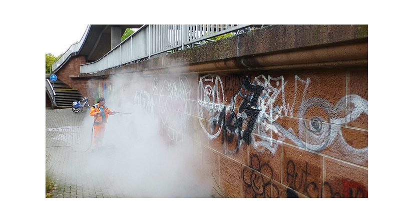 Das Foto zeigt einen Mitarbeiter des DBM bei der Beseitigung von Graffiti mit einem Dampfstrahler. © DBM, Sonja Stender
