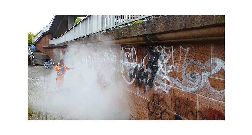 Graffitibeseitigung am Südbahnhof_Heißwasser Das Foto zeigt einen Mitarbeiter des DBM bei der Beseitigung von Graffiti mit einem Dampfstrahler. © DBM, Sonja Stender